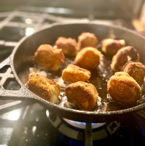 corn dog bites cooked to a golden crisp in a cast iron pan